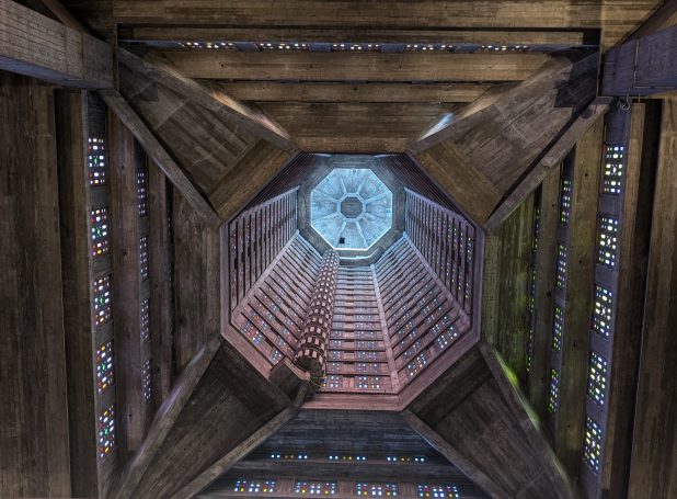 Looking up from the base of a wooden tower with a circular skylight above.