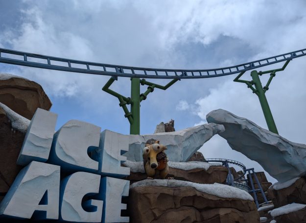 Theme park scene featuring an "Ice Age" display with a character on a snowy landscape.