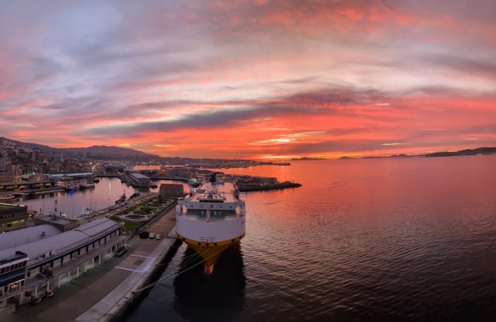 Sunset over Vigo harbour with a large ferry docked and vibrant sky colours.