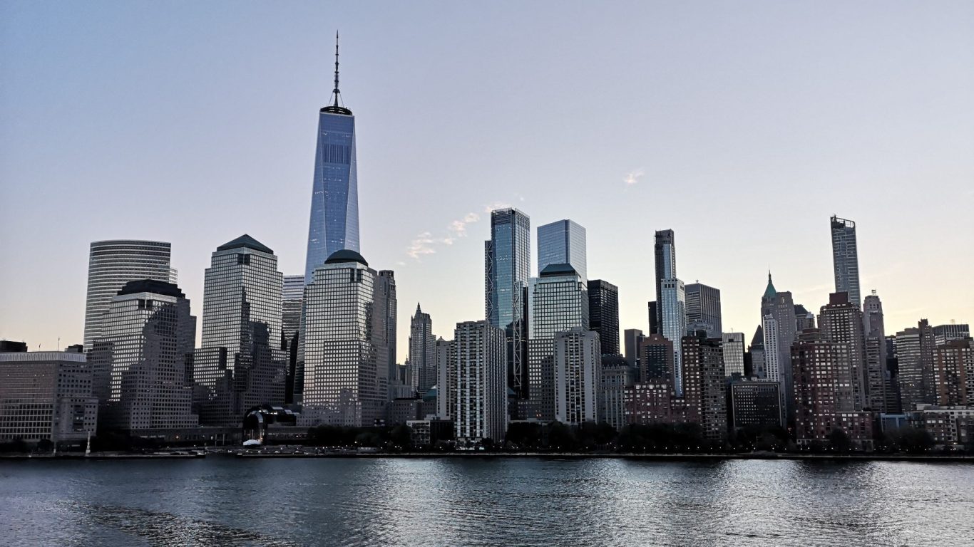 Skyline of New York City featuring One World Trade Center at dusk.