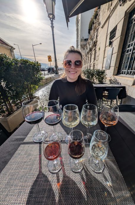 I&B's Founder posing with 8 wine glasses, while wine tasting in Lisbon